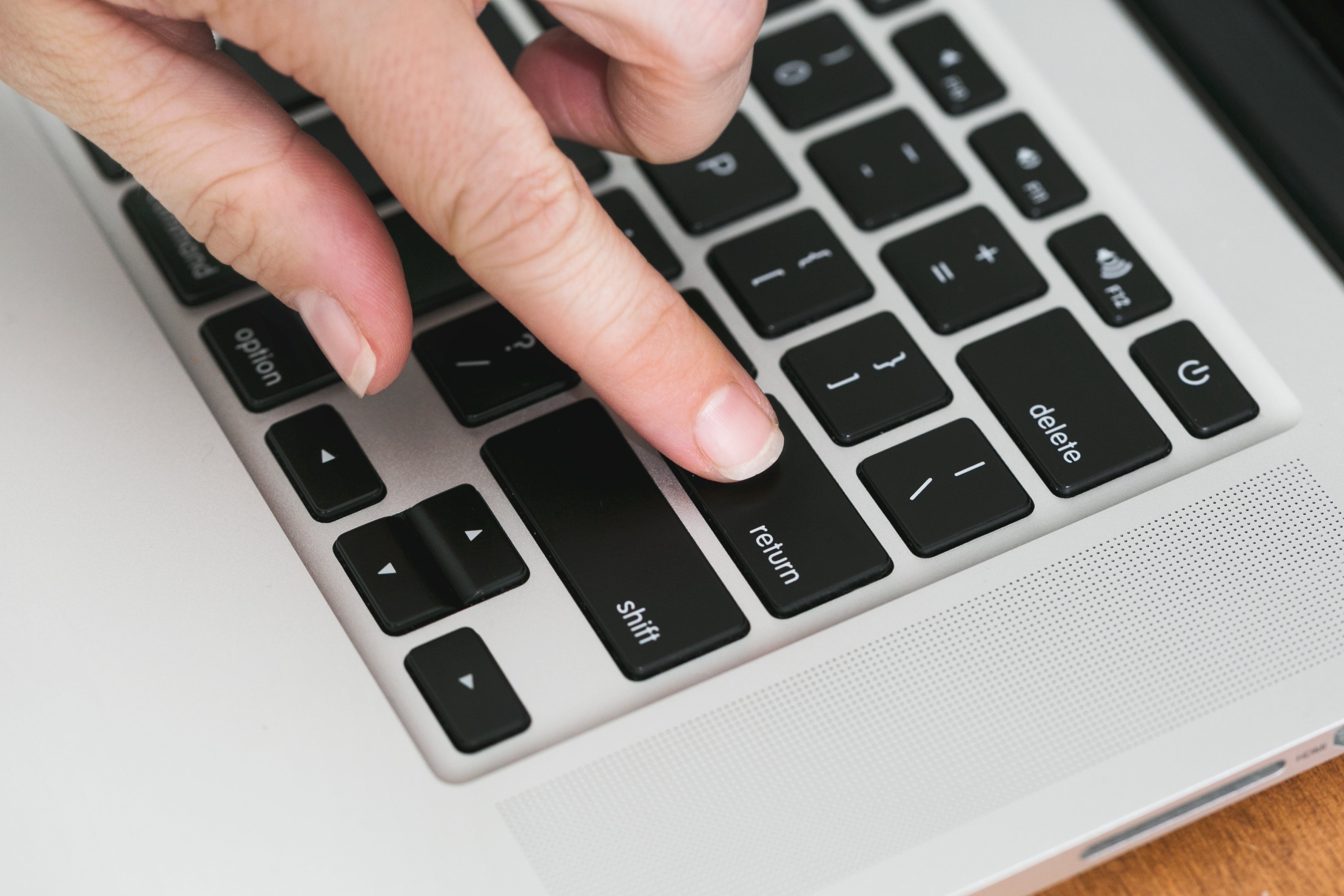 hand clicking the return button on a keyboard